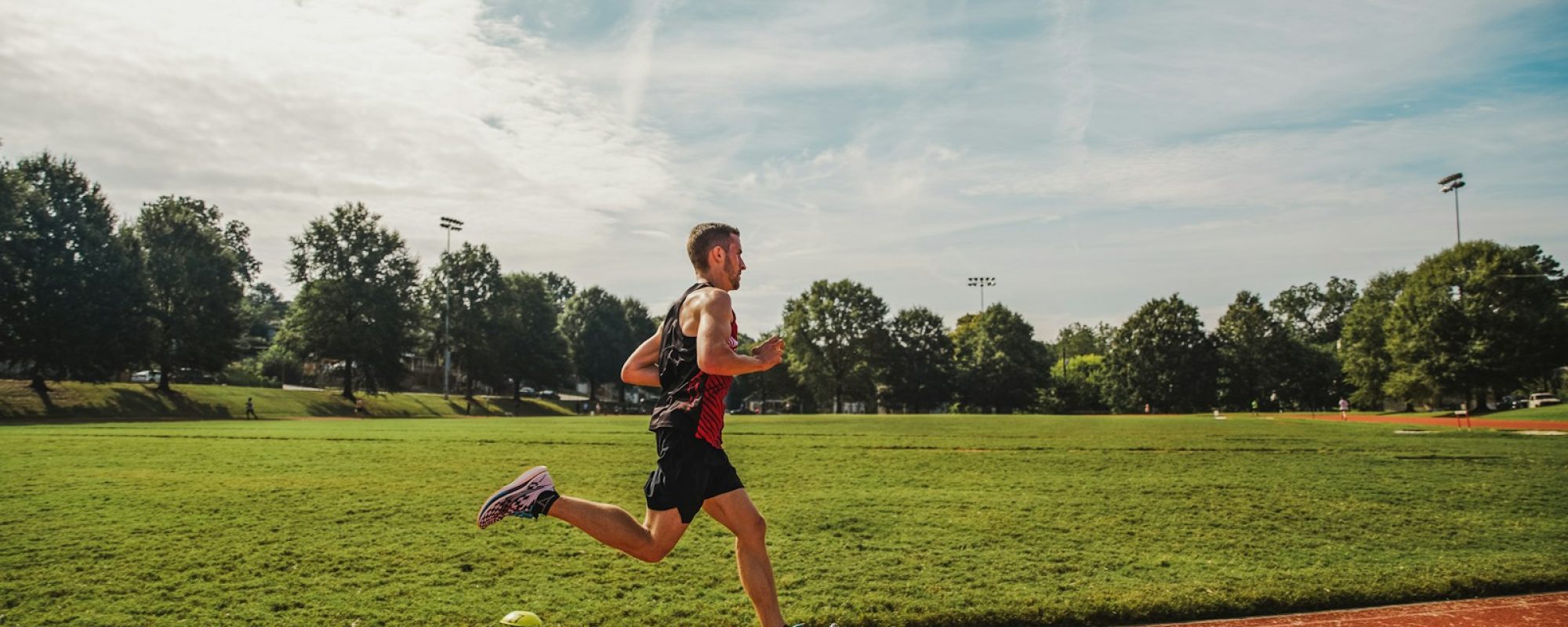 A man running across a field on a sunny day